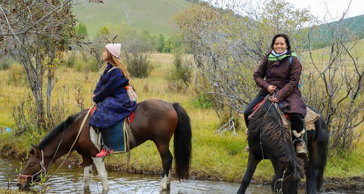 People on horseback in a forested area