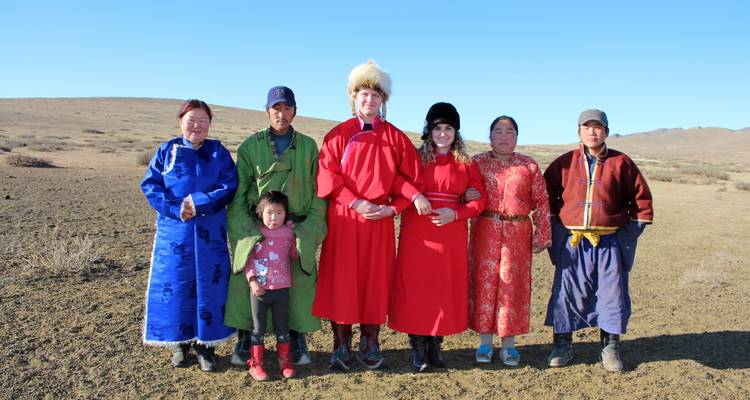 Gruppe von Einheimischen in traditioneller Kleidung, die in der Wüste posieren.