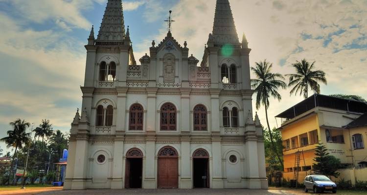 Een grote, sierlijke kerk met twee torens en een klok boven de hoofdingang.