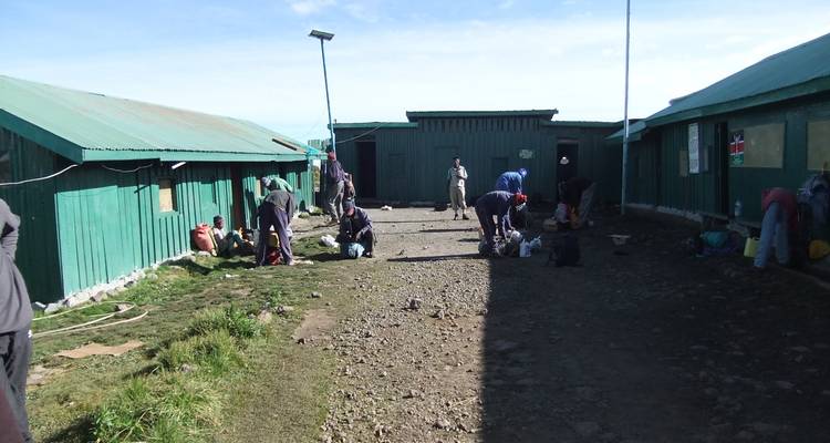 Kamp met mensen die uitrusting organiseren in een buitenomgeving.