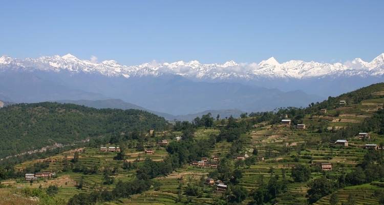 Huizen op terrasvelden met verre bergen.