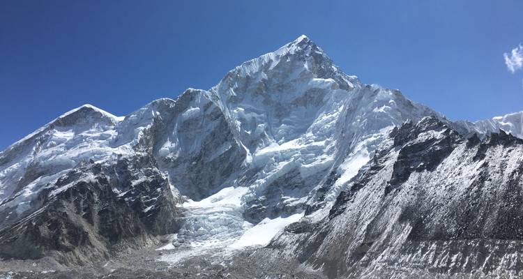 Schneebedeckter Berggipfel mit klarem blauen Himmel.