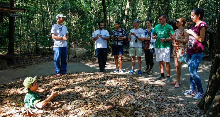 Turistas observando a un guía en los Túneles de Cu Chi, Vietnam.