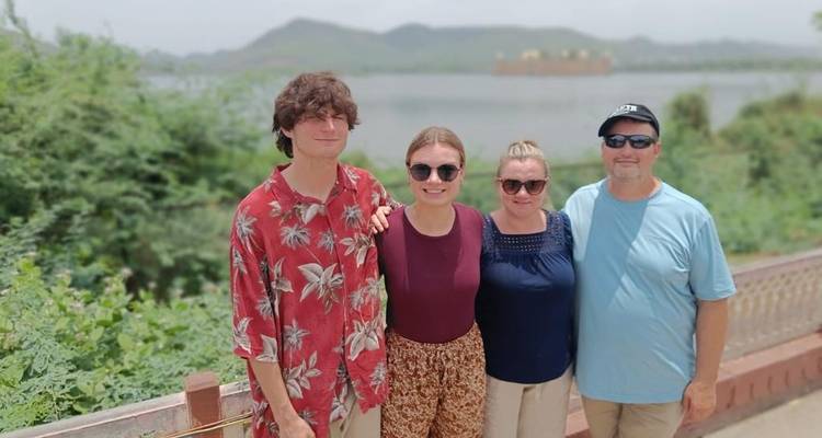 Een familie die poseert met een meer en heuvels op de achtergrond.