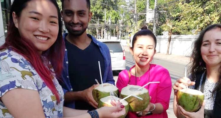Des gens qui dégustent des noix de coco dans la rue.