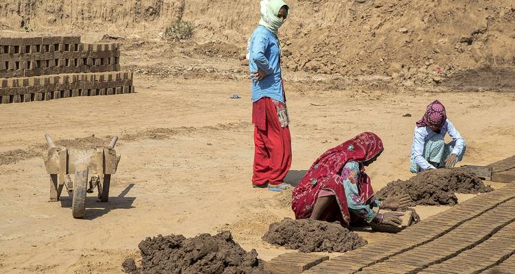 Mujeres trabajando en la fabricación de ladrillos en un entorno rural.