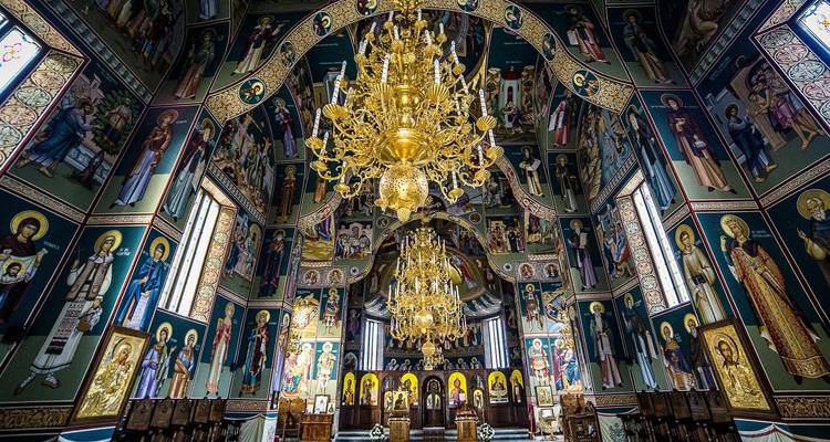 Ornate interior of a church with chandeliers and iconography.