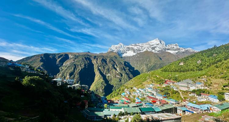 Picturesque mountain village with colorful rooftops and snowy peaks.