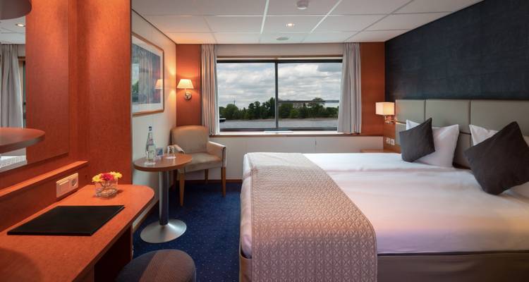 Intérieur d'une cabine de croisière fluviale avec vue par la fenêtre.