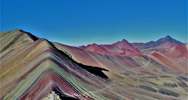 Regenboogberg met gelaagde kleuren en verre toppen.
