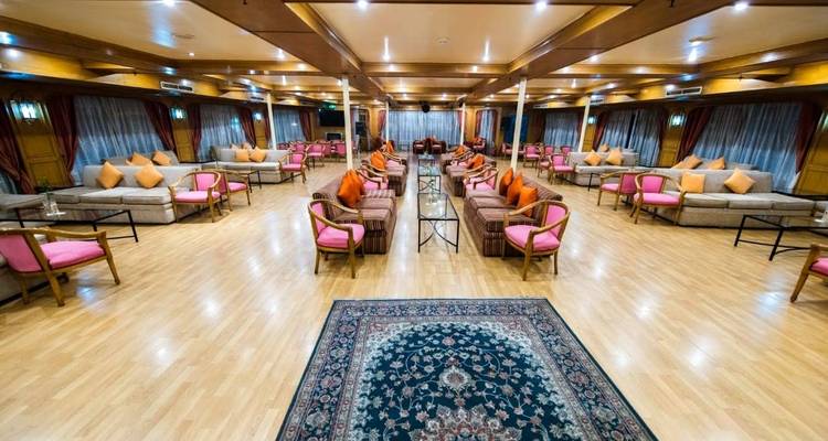 Een luxueuze zithoek binnen met banken en tafels.