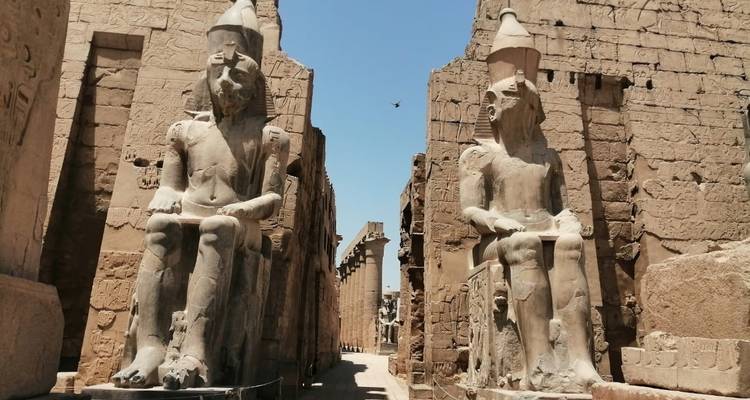 Oud-Egyptische tempel met beelden langs een pad.
