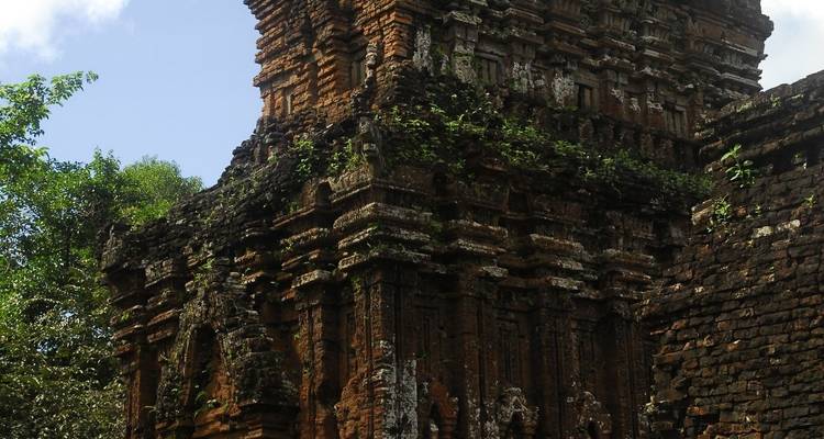 Antike Ziegelsteinruine eines Tempels mit darauf wachsender Vegetation.