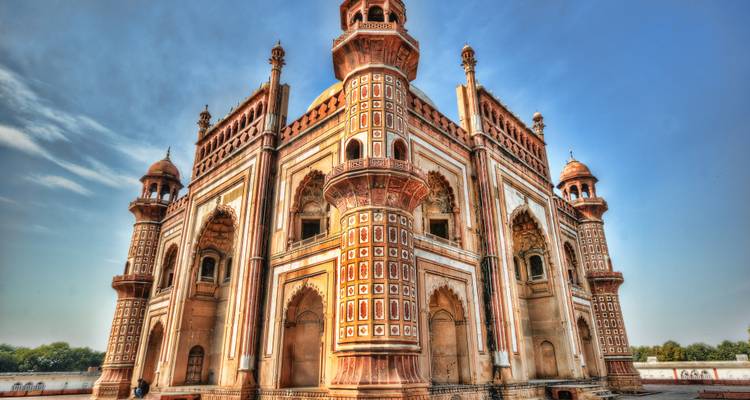 Fraai uitgevoerde rode zandstenen Safdarjung Tomb tegen een helder blauwe lucht.