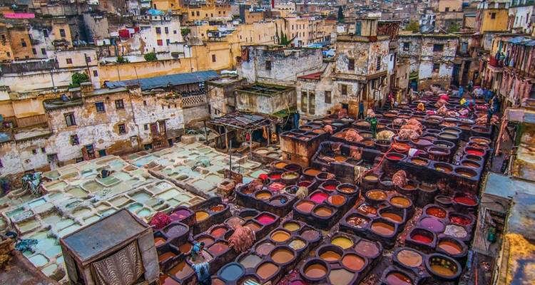 Zicht op leerlooierij met kleurrijke verfkuilen