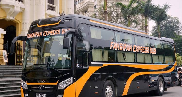 Autobús Fansipan Express estacionado frente a un edificio.