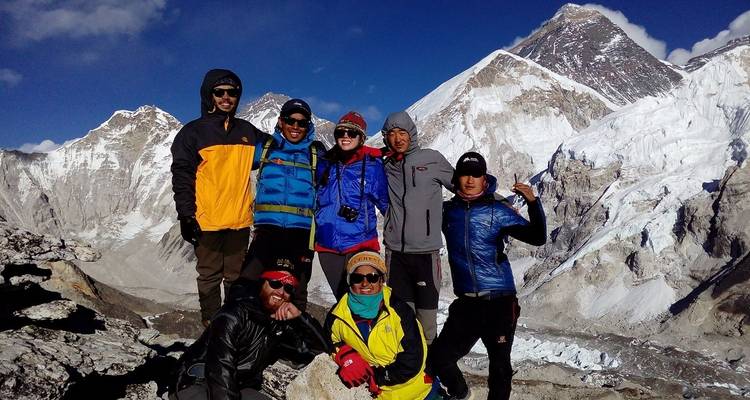 Groupe de randonneurs avec des montagnes enneigées en arrière-plan.