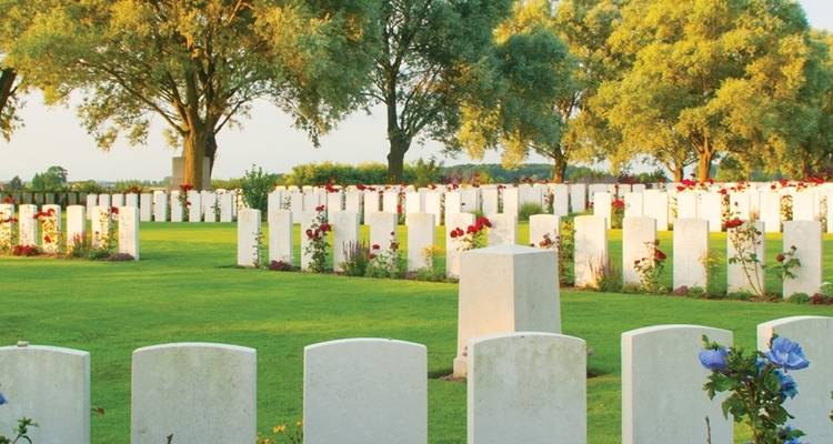 War cemetery with white headstones and flowers.