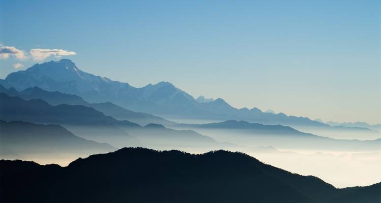 Geschichtete Berge mit Nebel in den Tälern.