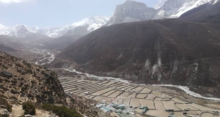 Mountainous terrain with settlements and river in a valley.