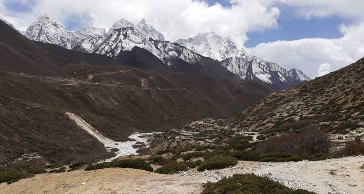 Mountain valley with snow-capped peaks and a river.