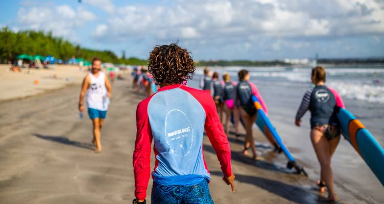 Grupo de personas preparándose para hacer surf en una playa.