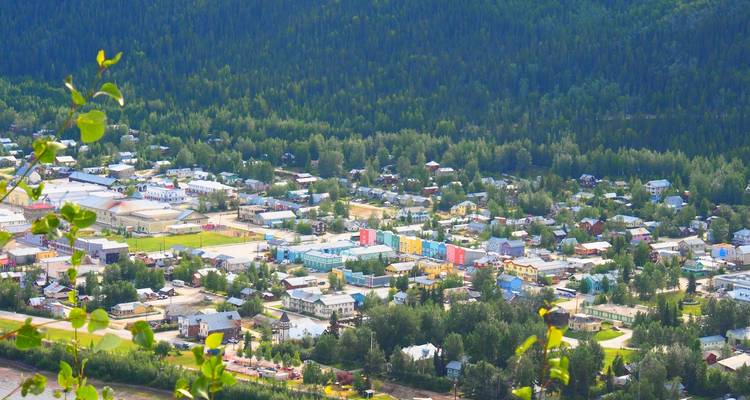 View of a town surrounded by dense forests and hills.