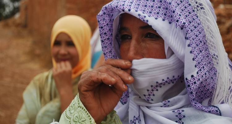 Women in colorful traditional attire standing outdoors.