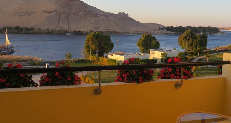 Flussblick von einem Balkon mit Blumen und Hügeln.