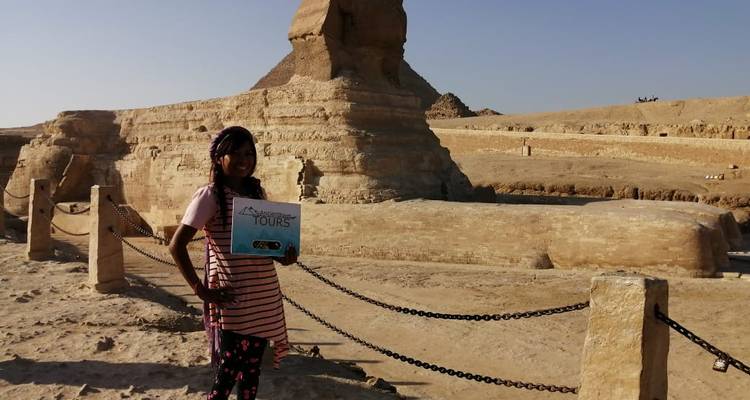 Person, die ein Schild hält, mit der Sphinx im Hintergrund.