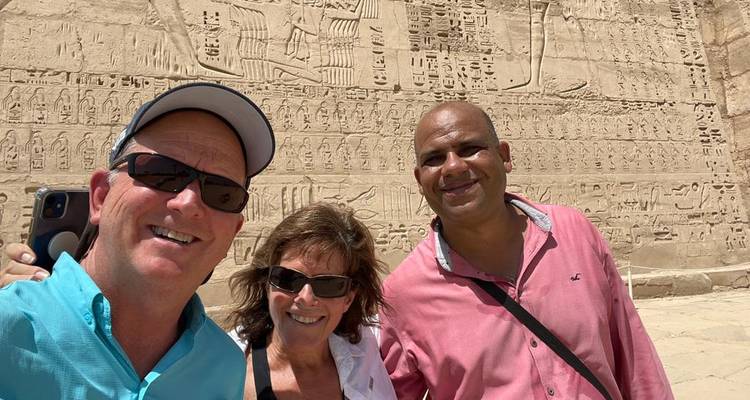 Group of tourists in front of ancient carvings.
