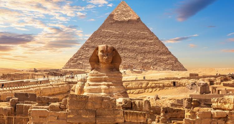 De Sfinx en piramide onder een opvallend kleurrijke hemel.