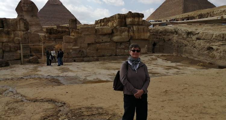 Persoon die voor oude ruïnes en piramides staat.