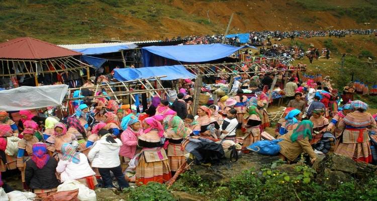 Market scene with crowds wearing colorful traditional attire.