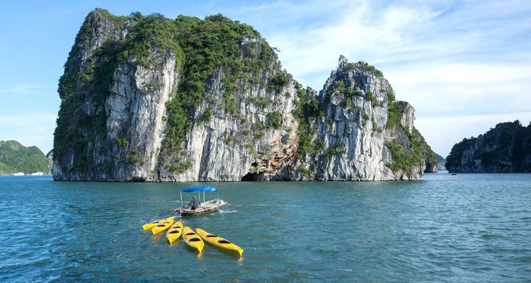 Yellow kayaks near rocky island formations.