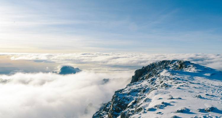 Snowy mountain ridge with dramatic clouds.