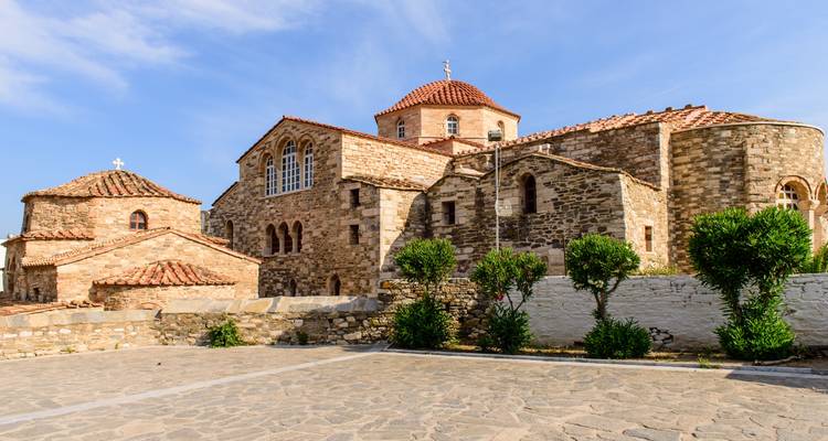 Iglesia histórica de piedra con techo de tejas rojas.