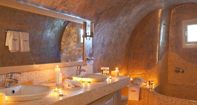 Baño lujoso con velas y una bañera.