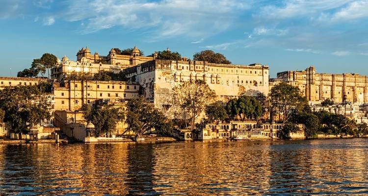 View of a grand palace by the lakeside with reflections on the water.