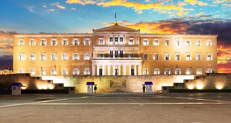 Bâtiment gouvernemental à Athènes au coucher du soleil avec un ciel coloré.