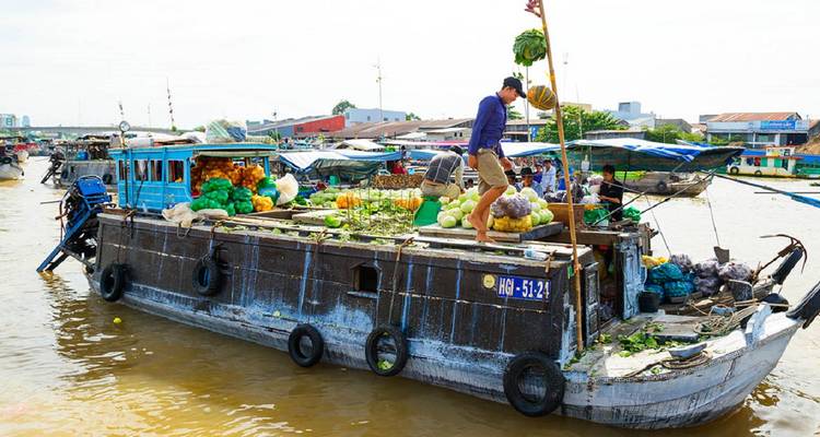 Un bote lleno de productos atiende a los clientes en un bullicioso mercado flotante del Delta del Mekong.