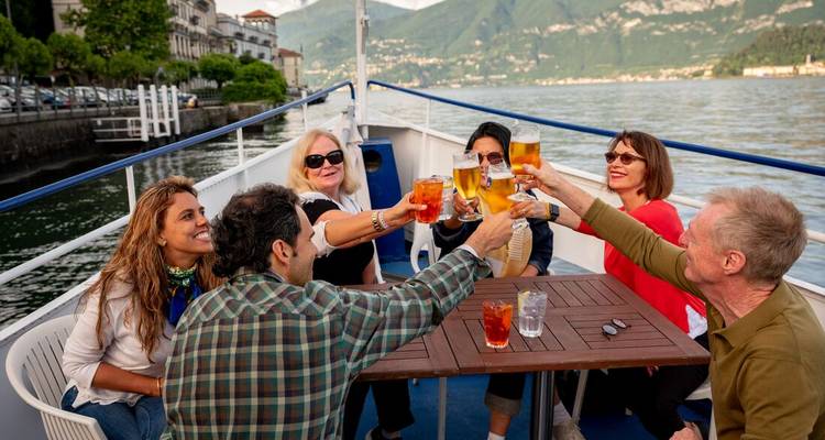 Groupe de personnes portant un toast sur un bateau au bord de l'eau.