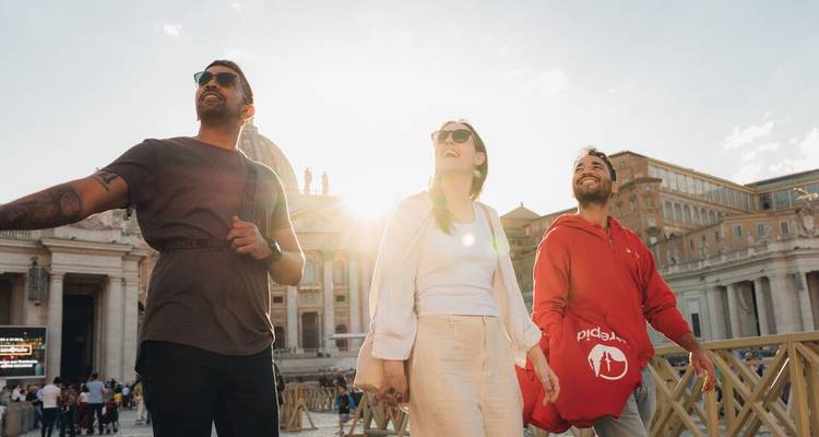 Trois amis profitent du soleil doré en faisant du tourisme sur la place Saint-Pierre avec la basilique derrière eux.