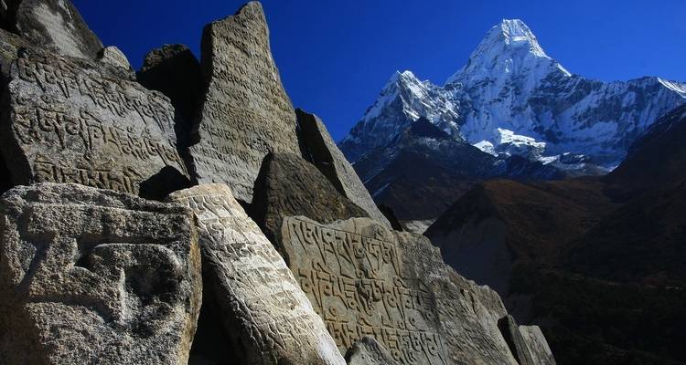 Besneeuwde berg met gegraveerde stenen op de voorgrond.