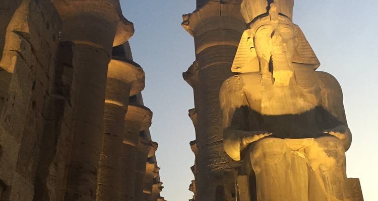 Verlichte antieke standbeeld bij zonsondergang in Egypte.
