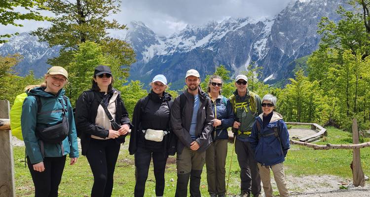Grupo de excursionistas frente a paisaje montañoso.