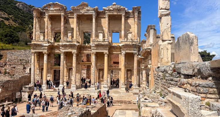 Des foules explorent la grande façade de l'ancienne bibliothèque de Celsus à Éphèse sous un ciel d'un bleu éclatant.
