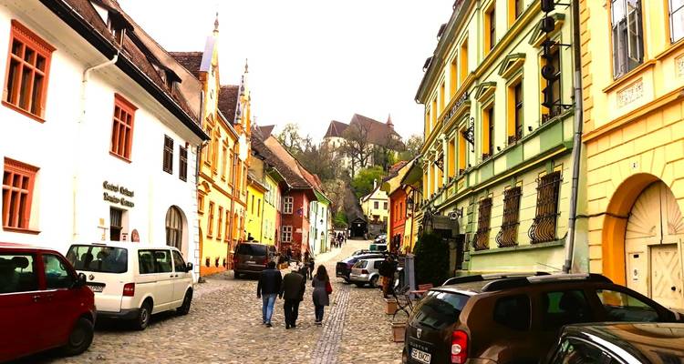 Een levendige straat met kleurrijke gebouwen en wandelende mensen.
