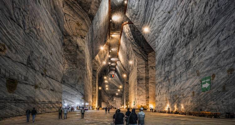 Vast illuminated chambers of an underground salt mine with visitors exploring.