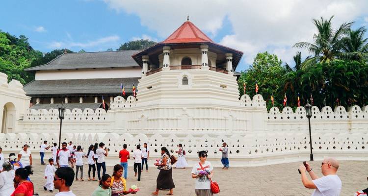 Menschen, die einen buddhistischen Tempel mit weißer Wand besuchen.